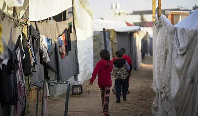Children walk through a temporary camp in southern Gaza. Photo: WHO